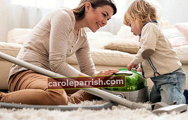 seorang ibu sedang membersihkan karpetnya tidak jauh dari anaknya