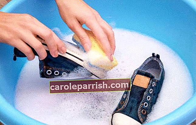 una persona lava le scarpe da ginnastica in una bacinella