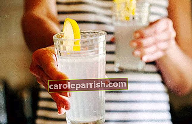 여자가 슬리밍 다이어트의 일환으로 레몬 주스 한 잔을 건네줍니다.
