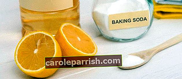 베이킹 소다 가루 항아리와 나무 숟가락으로 구운 소다로 반으로 자른 레몬